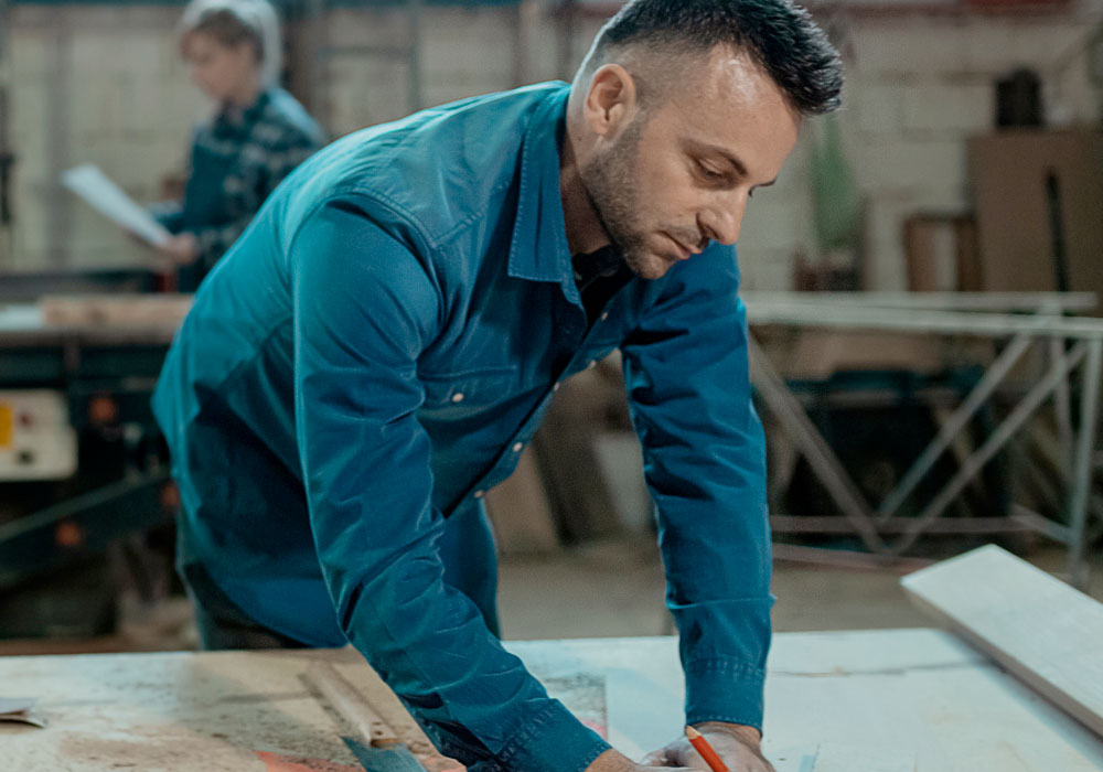warehouse team member carrying out technical drawings on a work surface