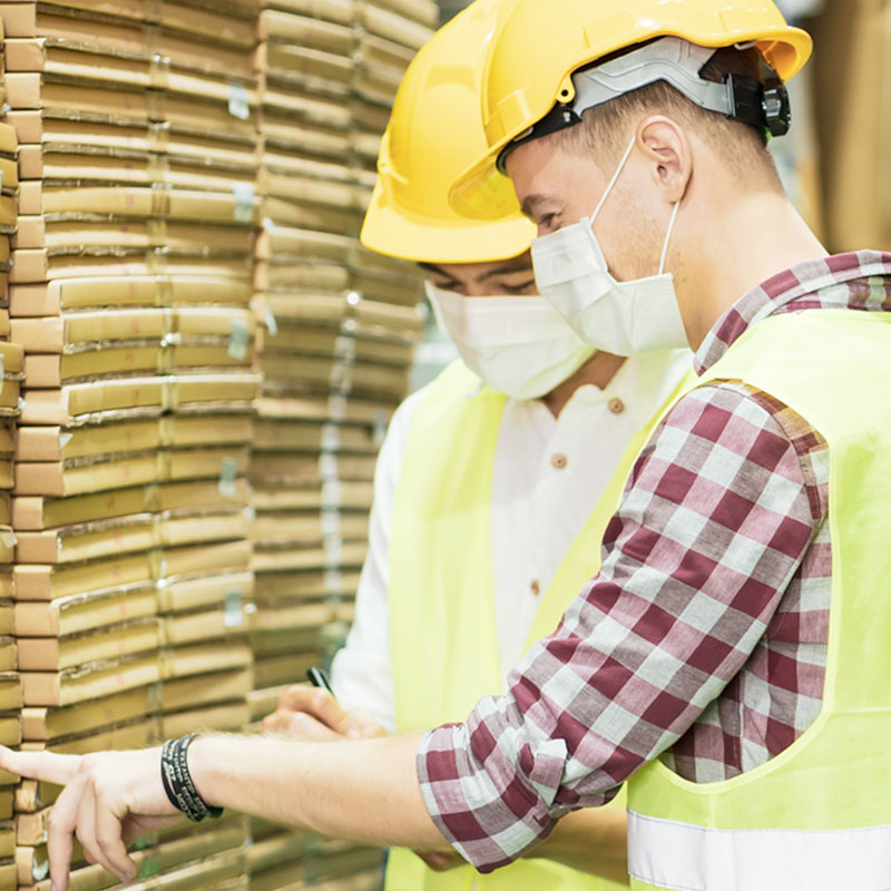 Two warehouse workers wearing PPE for safety purposes