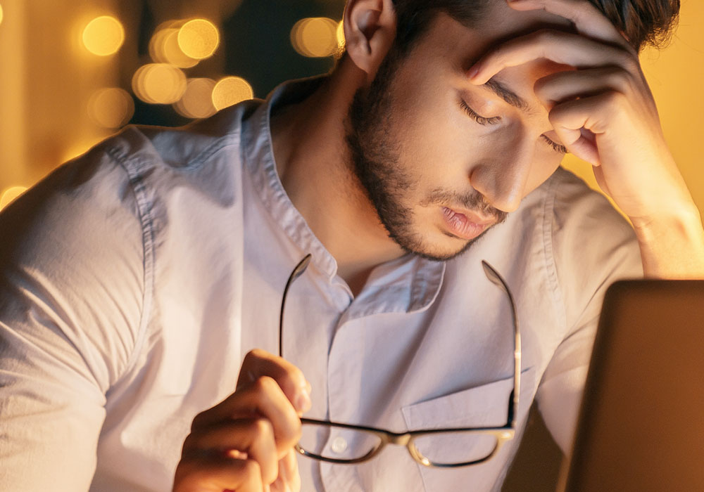 Employee at desk showing signs of stress